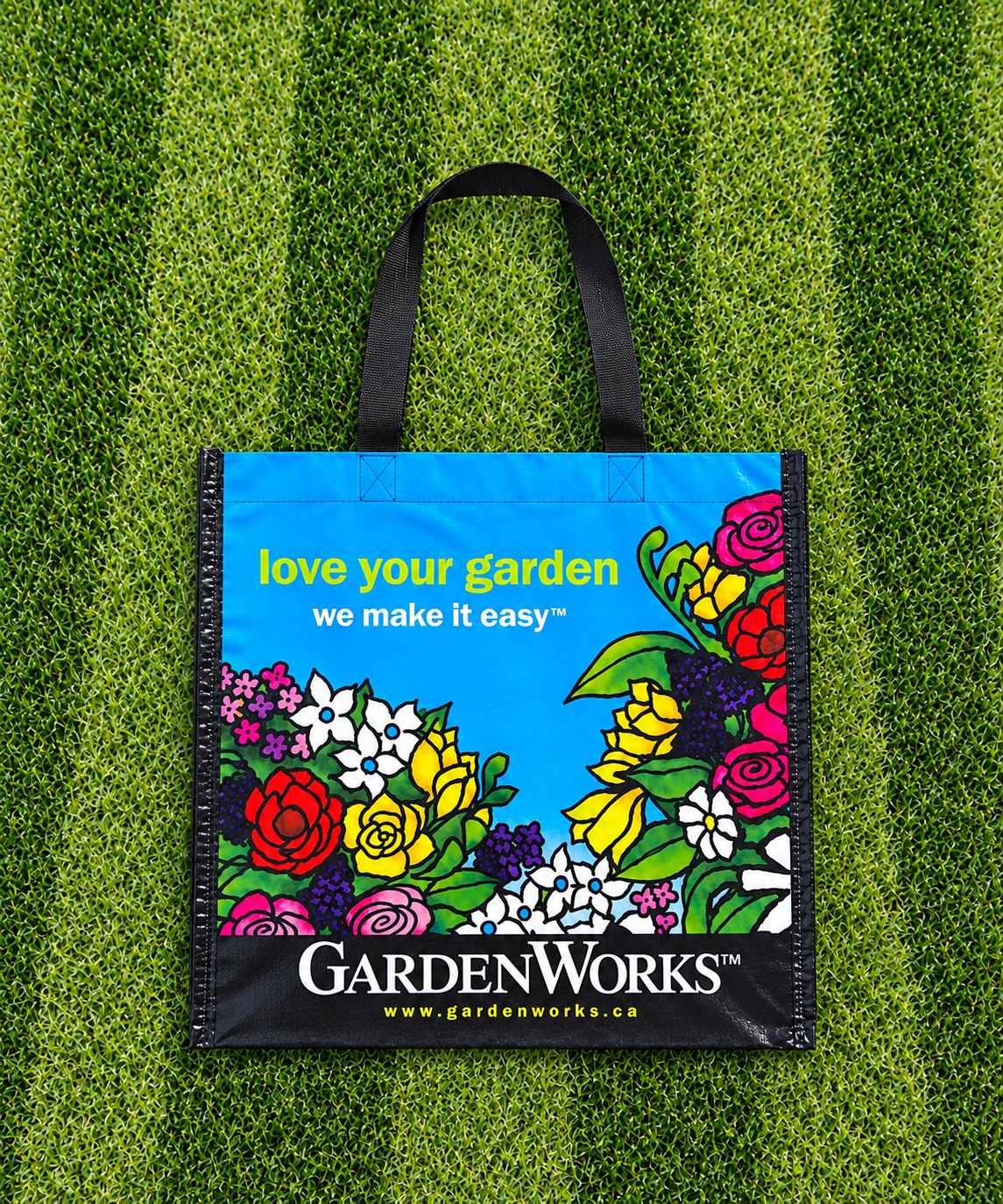 GardenWorks reusable woven shopping bag with garden graphics on a grass wall